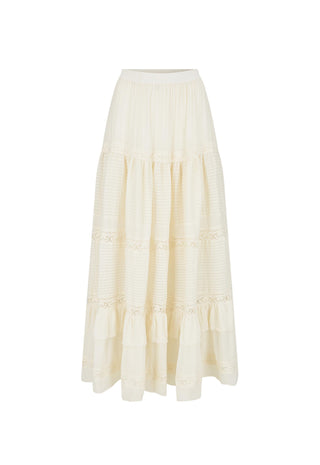 A woman modeling a cream-colored two-piece set consisting of a sleeveless crop top and a long tiered maxi skirt with lace details