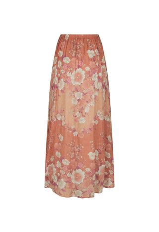 A woman wearing a flowing peach floral maxi dress with short puff sleeves and a V-neckline