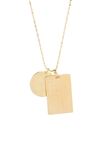 Close up back view of Spell’s Virgo Stargazer Zodiac Necklace charms. One charm is of a rectangular shape and an inspirational quote while the other charm is circular the brand name.